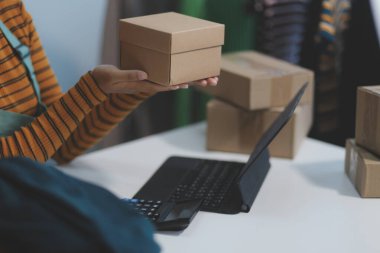 Vlogger, blog yazarı, küçük KOBİ iş kadını güzel bir kadın cep telefonuyla kıyafetleri satıyor canlı yayın satışı yapıyor, ana ofiste ürün sunumu detaylarını gösteriyor, girişimci ekommerce