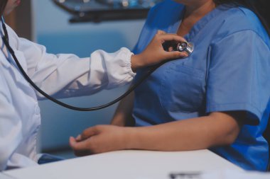 Doktor hastanede steteskopta kan basıncını ölçüyor..