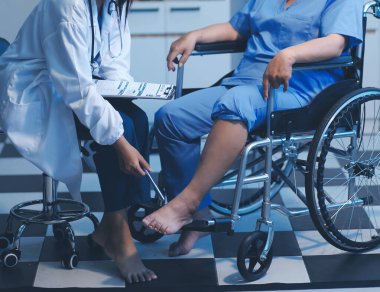 Asyalı, genç, profesyonel, dost canlısı mavi hastane üniformalı kadın hemşire yaşlı, yaşlı, sağlıksız, dört bacaklı, yürüyen bir hastanın fiziksel terapisine yardım ediyor..