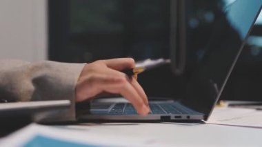 Ofiste bilgisayar ve belgelerle çalışan iş adamı.