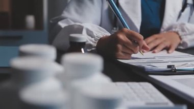 Doktorun elinde bir dosya tutarken ve hastanede reçete yazarken.