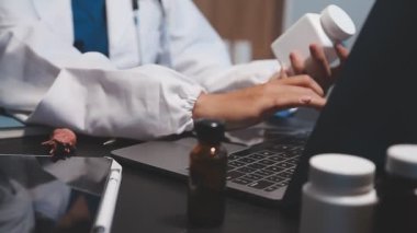 Beyaz önlüklü doktor elinde haplar ve ilaçlar tutuyordu.