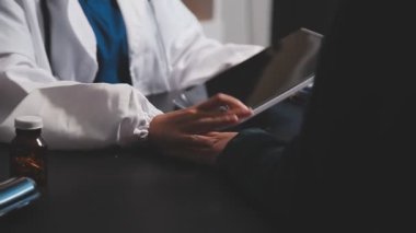 Doktorlar ve hastalar hastanede tıbbi muayeneyi tartışıyorlar.