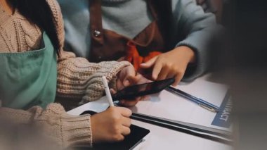 Kadın elinde kalemle dizüstü bilgisayar kullanıyor.