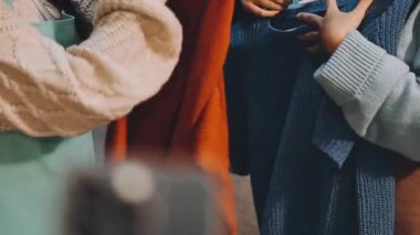 Kadınlar dükkanda fotoğraf çekmek için cep telefonu kullanıyor.