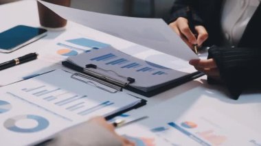 Bilgisayarla çalışan ve iş haritalarını tartışan bir iş adamının resmi..