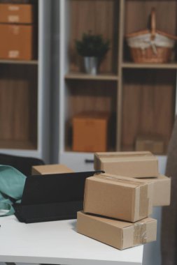 Vlogger, blog yazarı, küçük KOBİ iş kadını güzel bir kadın cep telefonuyla kıyafetleri satıyor canlı yayın satışı yapıyor, ana ofiste ürün sunumu detaylarını gösteriyor, girişimci ekommerce