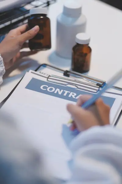 stock image Doctor sitting at desk and writing a prescription for her patient