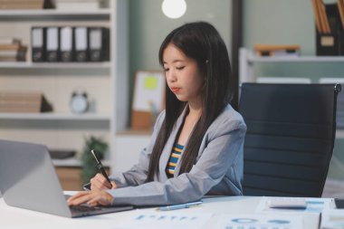 Ofiste dizüstü bilgisayarda çalışan neşeli iş kadını, iş yerinde resmi takım elbiseli Asyalı mutlu iş kadını. Çekici bayan ofis çalışanı gülümsemesi.