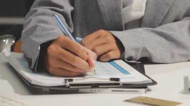 İş adamı harcamaları hesaplıyor ve ofiste hesap makinesi kullanıyor..