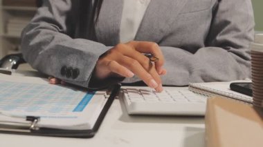 Genç iş kadını ofiste çalışıyor, notlar yazıyor.