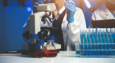 Bilimsel araştırmalar için bilimsel mikroskop kullanan profesyonel kimyager kadın laboratuvarı, mikrobiyoloji medikal ekipman teknolojisi ile çalışan kimya bilimcisi tıp biyolojisi deneyi için çalışan