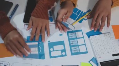 Genç bayan tasarımcı, meslektaşlarıyla birlikte dijital tablet taşıyor.