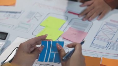 yaratıcı ekip ekranda mobil uygulama ile yeni projeyi tartışıyor.