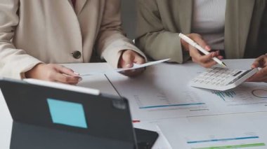 Bir dizüstü bilgisayar ve finansal grafikle iş ekibi toplantısı