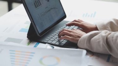 İşadamı ofiste dizüstü bilgisayar ve hesap makinesiyle çalışıyor.