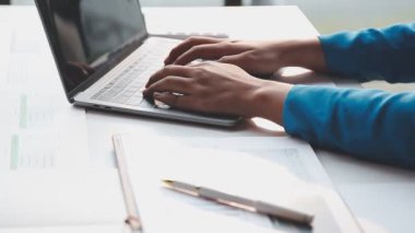 İş adamları modern ofiste dizüstü bilgisayar ve defterle çalışıyorlar..