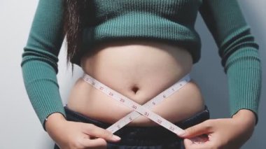 Şişmanlığını ölçen Asyalı kadın.