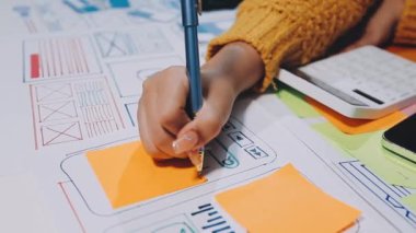 Ofiste akıllı bir telefonla çalışan tasarımcı.