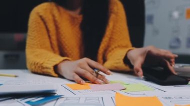 genç bayan tasarımcı ofis masasında proje üzerinde çalışıyor.