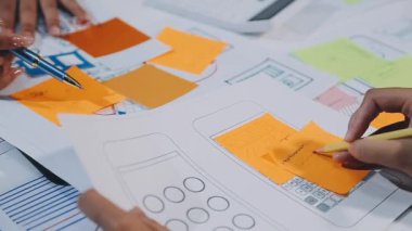 Bayan mimar planda yapışkan bir nota yazıyor.