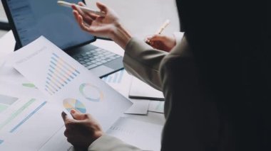 İş adamları finansal verileri tartışıyor ve beyin fırtınası yapıyorlar.