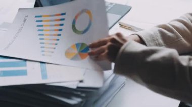 İşadamı grafiği analiz ediyor ve masadaki bilgisayarı kullanıyor