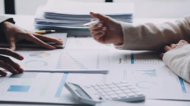 Ofiste belgelerle çalışan iş kadını, dizüstü bilgisayarla çalışan iş adamları