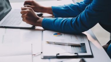 Ofiste dizüstü bilgisayar ve defterle çalışan bir iş adamı.