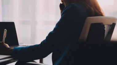 Geceleri ofiste bilgisayar başında çalışan genç bir kadın.