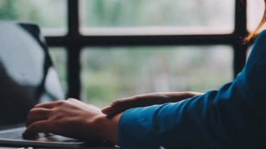 Ofisteki ahşap masada otururken akıllı telefon kullanan adam..