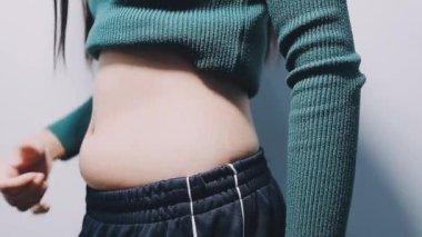 Stüdyoda göbeği olan genç bir kadın.