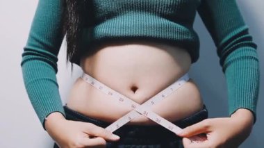 Göbeğini ölçen hamile kız.