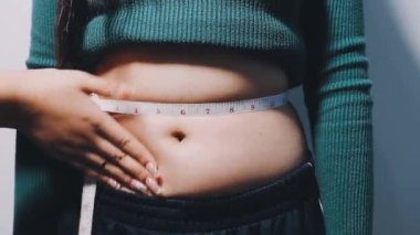 Hamile göbeği şeklinde mezurası olan bir kadın.