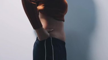 Genç ve güzel bir kadın karnını tutuyor.