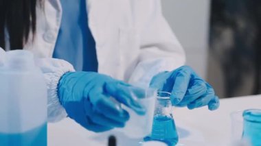 Laboratuvarda pipetle tüpü tutan bilim adamlarının ellerini kapatın. Test tüplü laboratuar asistanı.