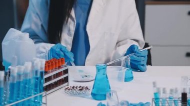 Kimyasal deney yapan genç bir kadın kimyager.