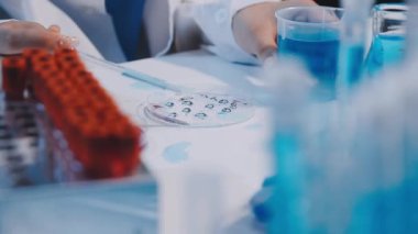 Test tüpünü sıvı ile tutan bir bilim adamının görüntüsü.