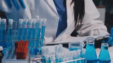 Laboratuvar önlüklü bilim adamı laboratuarda deney yapıyor.