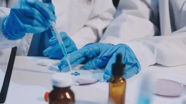 yakın plan - beyaz önlüklü kadın doktor labaratuvarda mavi sıvı ile.