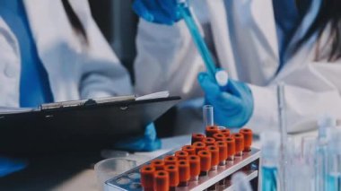 Test tüpüyle çalışan bir laboratuar asistanını kapat.