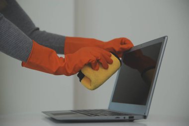 Evde bez ve dağıtıcı kullanan kadın masasını temizliyor.