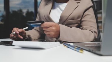 Genç adam ofiste masa başında otururken cep telefonu kullanıyor.