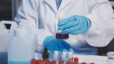 Laboratuvarda deney tüpleriyle çalışan bilim adamı..