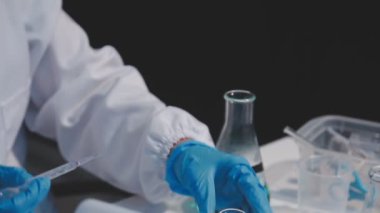 Test tüpünü sıvı ile tutan laboratuvar çalışanının etrafını kapatın.