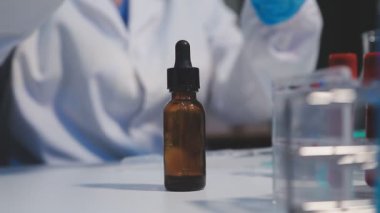 Bir tıp laboratuvarında elinde aşı şişesi olan bir doktor.