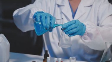 Laboratuvarda sıvı içeren matarayı tutan kadın laboratuvar asistanı.