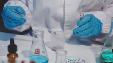 Laboratuvar bilim adamı deney tüpünü sıvı ile tutuyor..