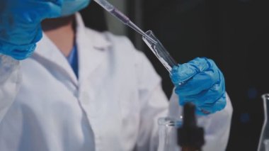 Laboratuvarda koruyucu eldivenleri olan bilim adamı.