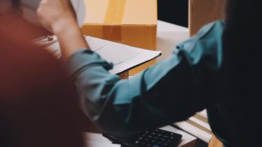 Yakın plan - Ofiste karton paket ve kalemle bir paketi tutan bir erkeğin resmi